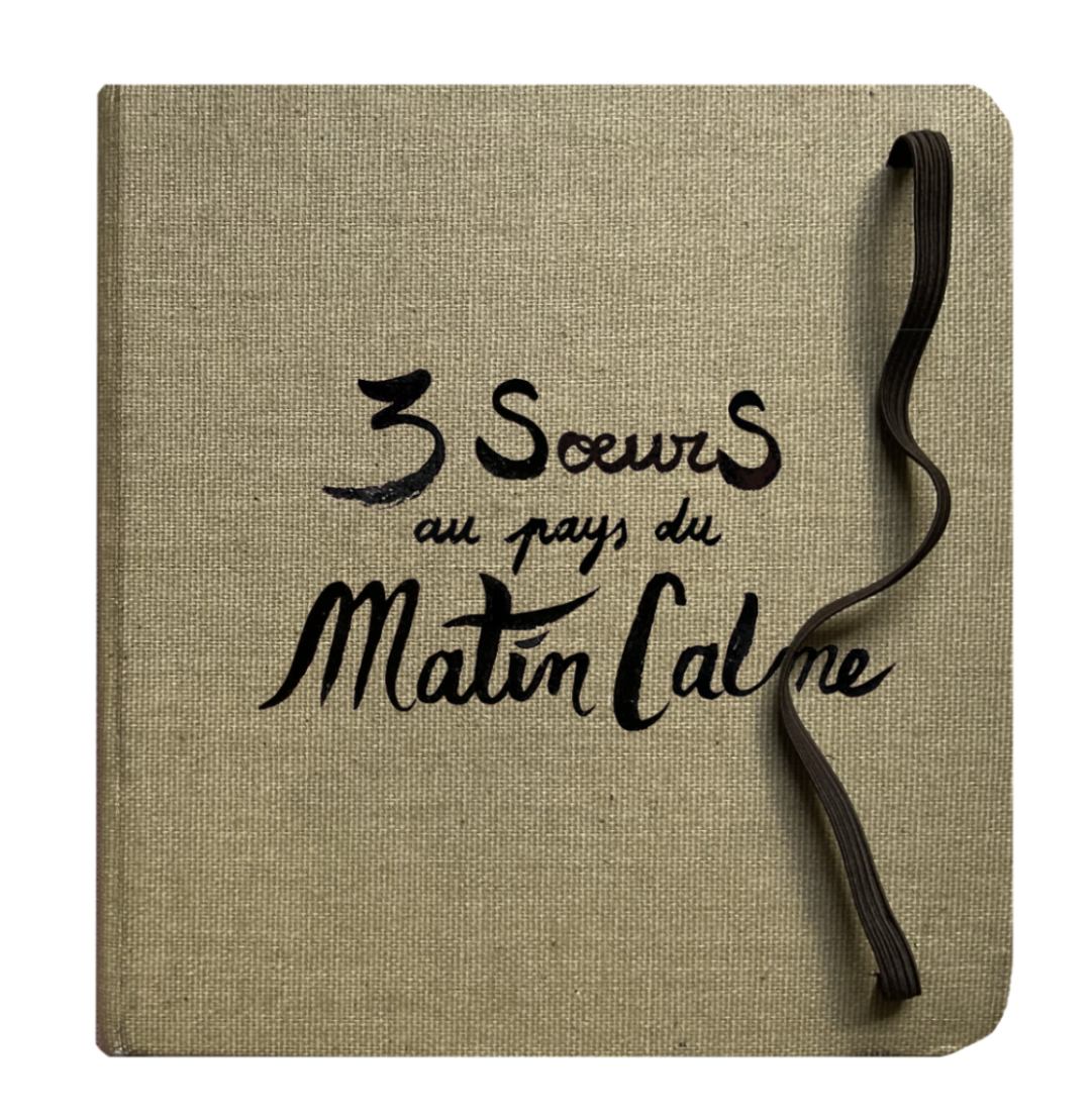 couverture du carnet 3 soeurs au pays du matin calme. son format est carré, sa couverture marron-beige et le titre est écrit à la main dessus avec une écriture cursive, le carnet a un élastique qui permet de le fermer
